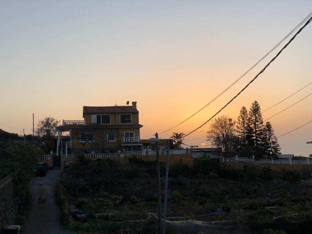 una casa sentada en la cima de una colina con la puesta de sol en Atlantic views, en Tacoronte
