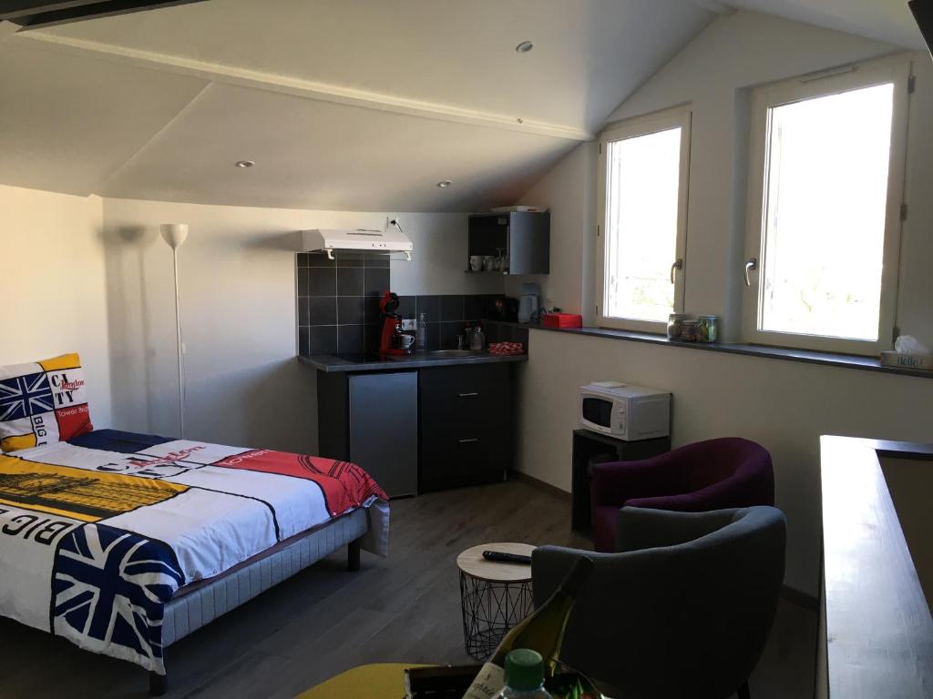 1 dormitorio pequeño con 1 cama y cocina en Studio Cosy, en Cognac