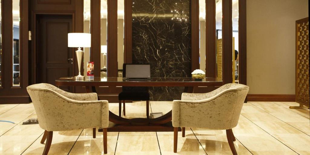 a desk with two chairs and a table with a laptop at Crowne Plaza Istanbul Oryapark by IHG in Istanbul