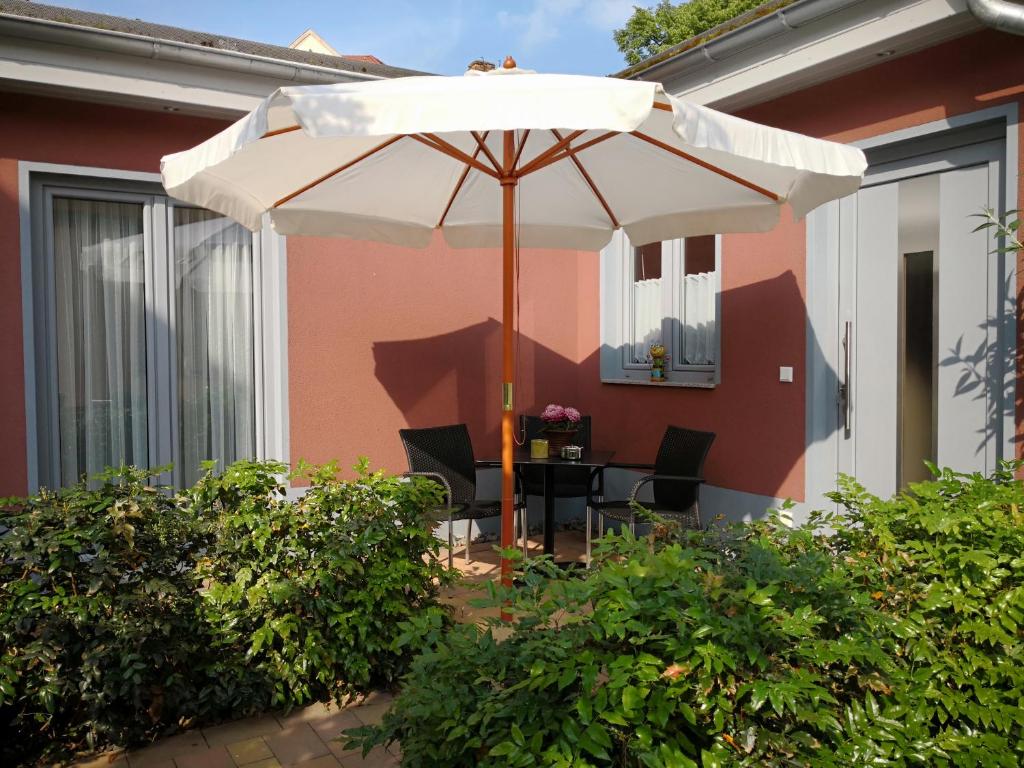 un patio con sombrilla, mesa y sillas en Kleines feines Ferienhaus im Herzen von Dresden en Dresden
