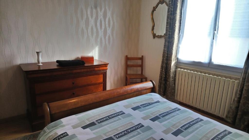 a bedroom with a bed and a dresser and a window at Chambre au calme et simple, cuisine à dispo in Saint-Pol-de-Léon