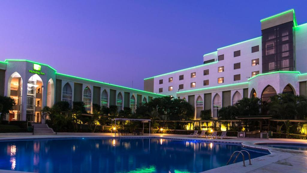 um hotel com piscina em frente a um edifício em Holiday Inn Tuxtla Gutierrez, an IHG Hotel em Tuxtla Gutiérrez