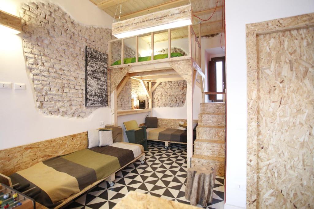 Habitación con 2 camas y pared de piedra. en Wehomes - TinyHouse - RhoFiera Milano self check-in, en Rho