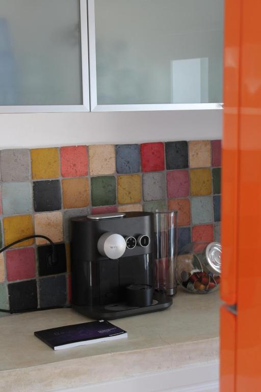 a kitchen counter with a coffee maker on a counter top at By The Mill in Oia