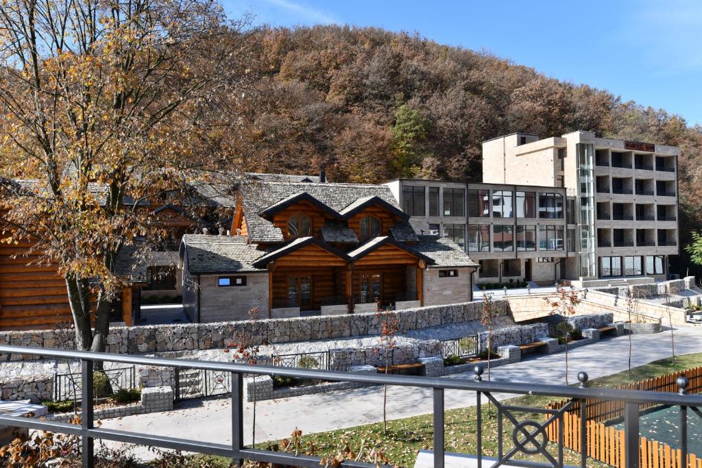 ein Gebäude vor einem Gebäude mit einem Berg in der Unterkunft HOTEL EMROVIC RAJ in Novi Pazar