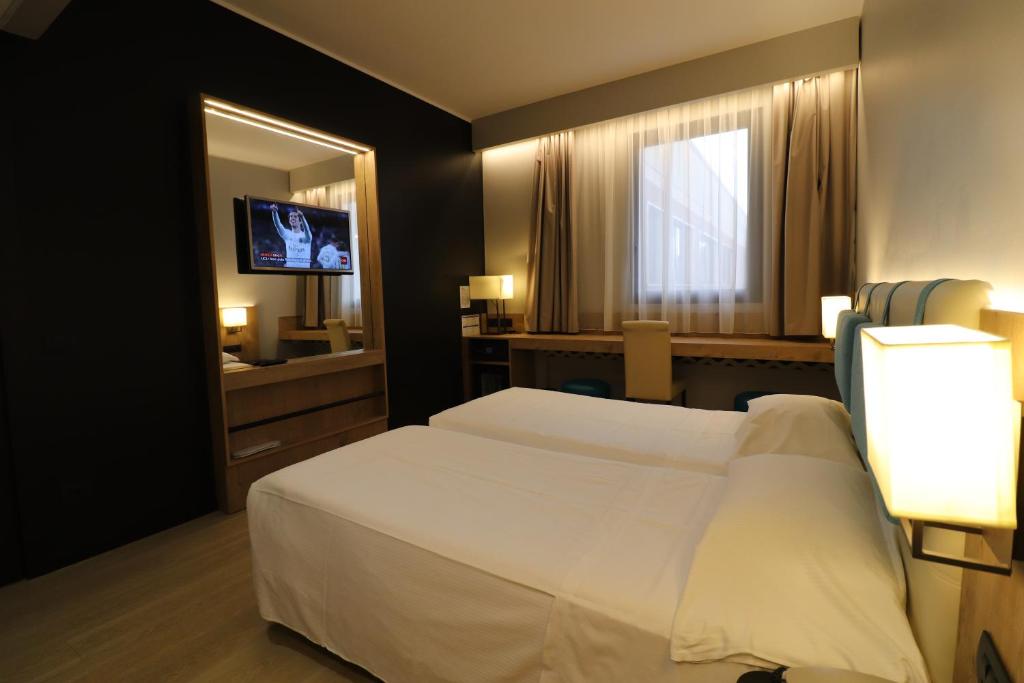 Postel nebo postele na pokoji v ubytování Hotel Domenichino