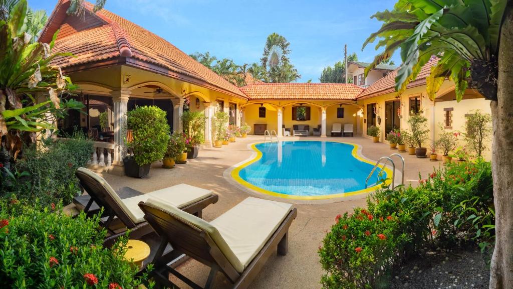una vista exterior de una casa con piscina en Coconut Paradise Villas, en Rawai Beach