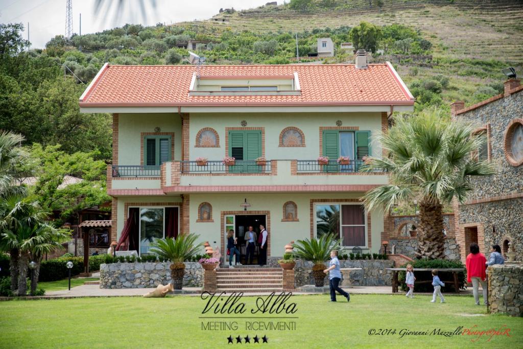 a group of people standing in front of a house at B&B Villa Alba in Messina