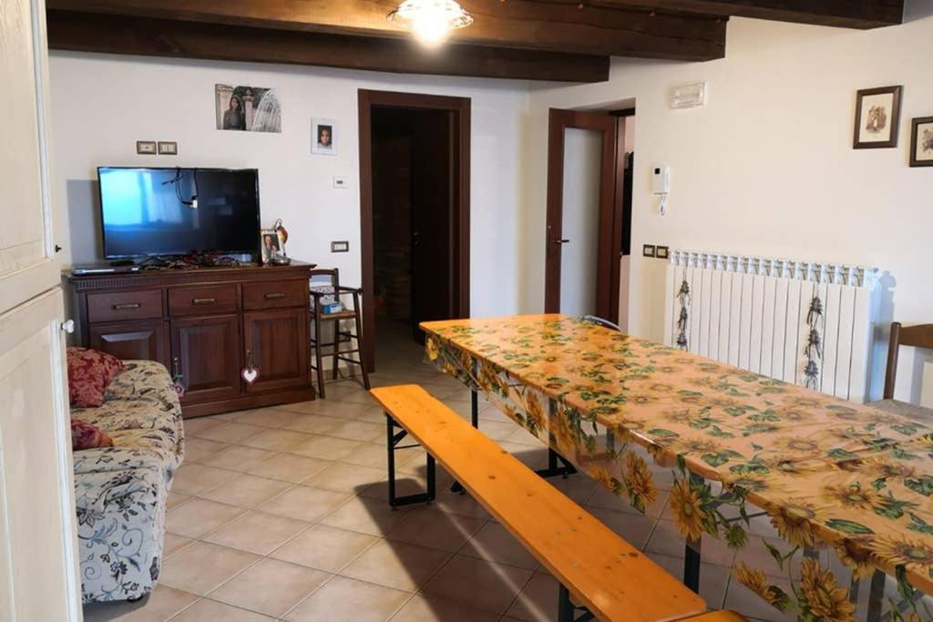 salon ze stołem i telewizorem w obiekcie Residenza Il cortile w mieście Monte San Martino