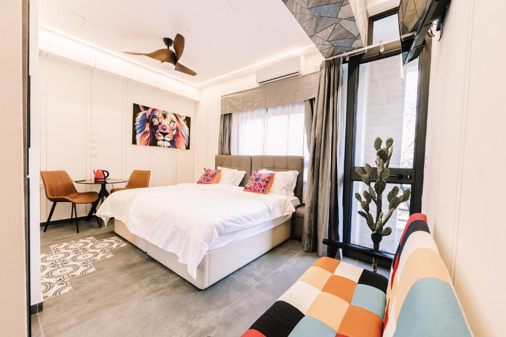 1 dormitorio con cama blanca y ventana en King's Rooftop Studios en Tel Aviv