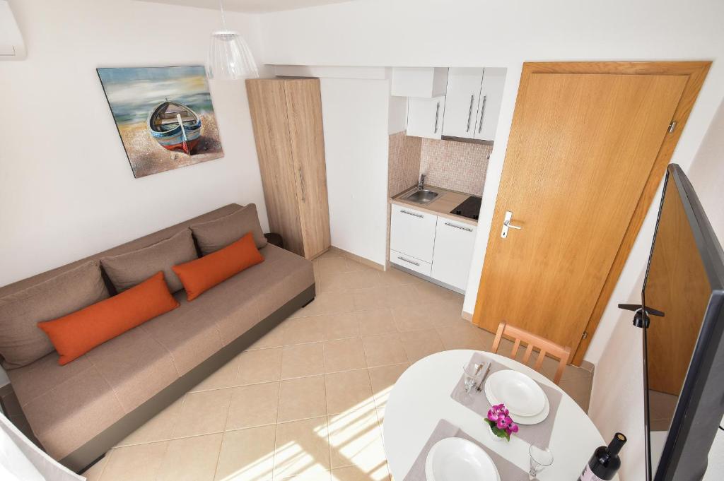 een kleine woonkamer met een bank en een tafel bij Apartman Mia in Igrane
