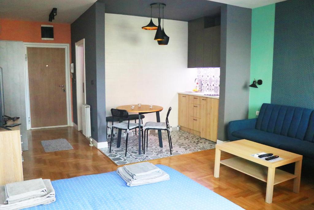 uma sala de estar com um sofá azul e uma mesa em TiTo em Belgrado