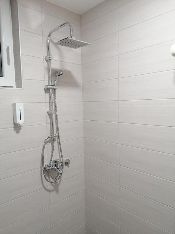 a shower in a bathroom with white tiles at Airport view Apartment in Belgrade