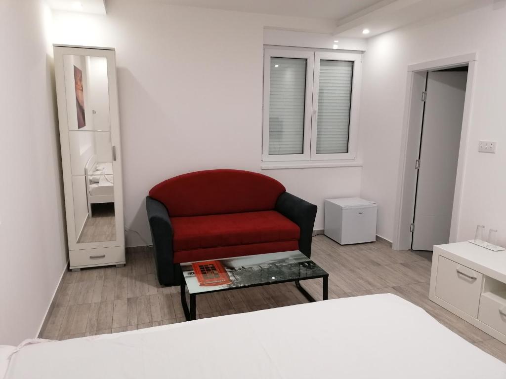 a living room with a red chair and a table at Airport view Apartment in Belgrade