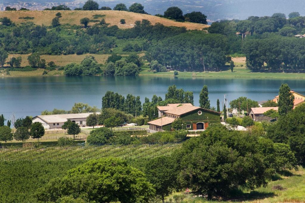 a house on a hill next to a lake at Agriturismo Potrero Grande in Campagnano di Roma