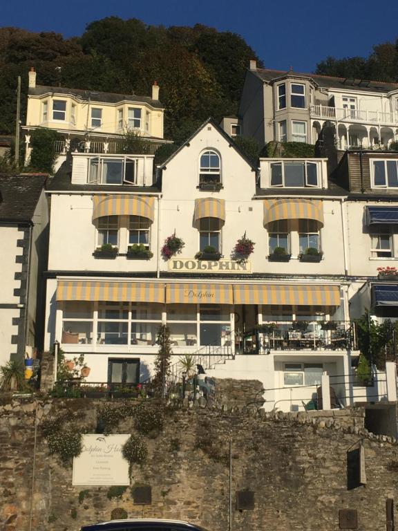 a white building on top of a hill at Dolphin Guest House in Looe