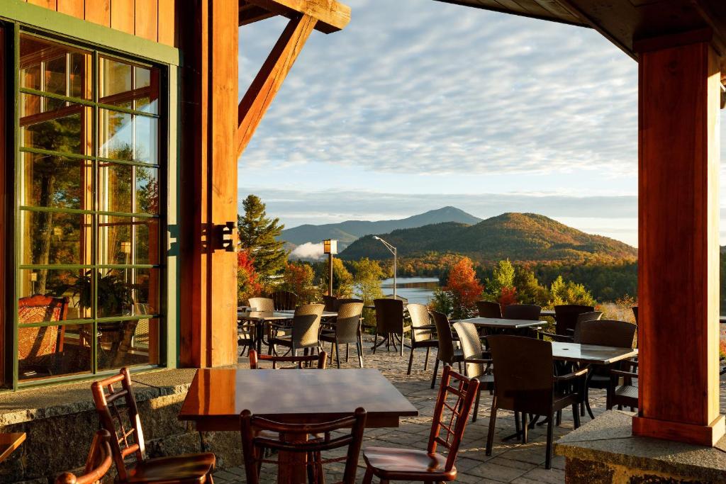 d'une terrasse avec tables et chaises et vue sur les montagnes. dans l'établissement Crowne Plaza Lake Placid, an IHG Hotel, à Lake Placid