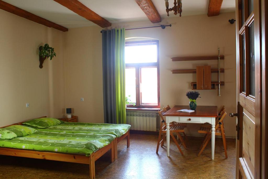 a bedroom with a bed and a table and a window at Apartamenty i pokoje gościnne "Wacuś" in Srebrna Góra