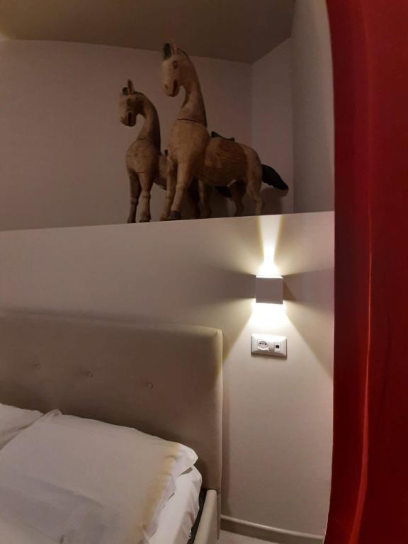 Pokój z łóżkiem i lampką z końmi na ścianie w obiekcie Hotel & Ristorante L'Angoletto in Selci w mieście Selci