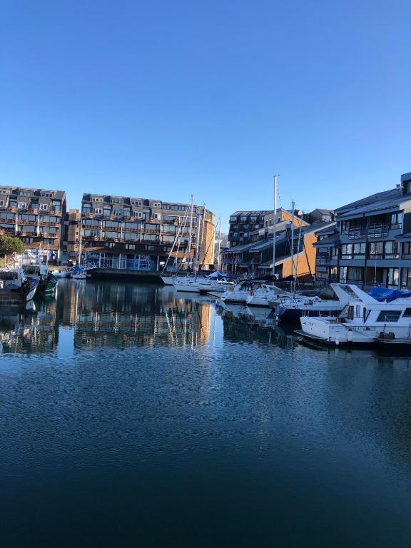 un groupe de bateaux amarrés dans un port de plaisance comportant des bâtiments dans l'établissement Grande Marina Vue Port, à Deauville