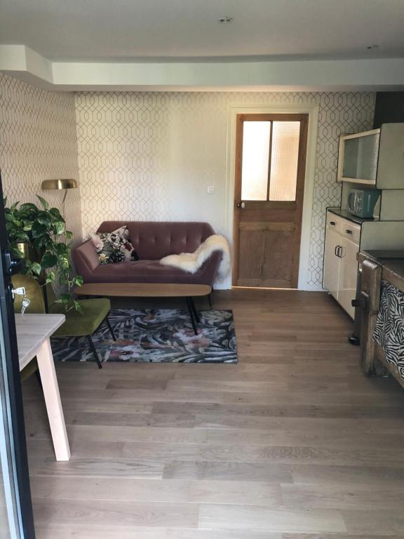 ein Wohnzimmer mit einem braunen Sofa und einer Tür in der Unterkunft Appart Jungle in Clermont-Ferrand