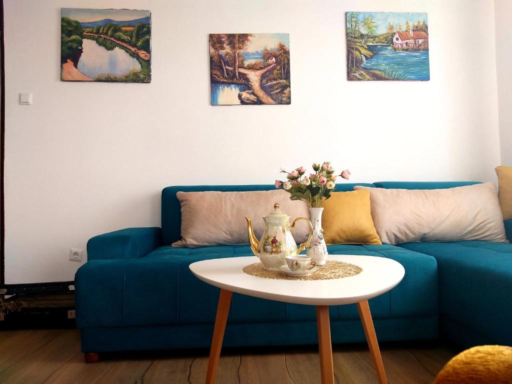 リュブシュキにあるMagnoliaのリビングルーム(青いソファ、テーブル付)