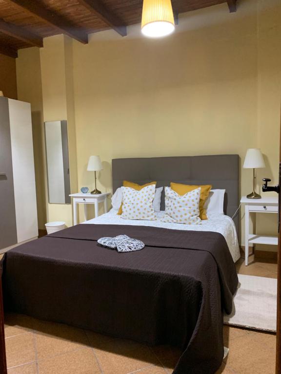 Un dormitorio con una cama grande con almohadas amarillas y blancas en Daniella, en Ingenio