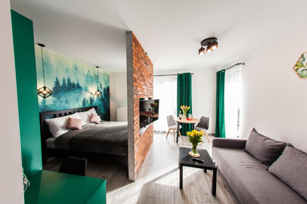 um quarto com uma cama e uma sala de estar com um sofá em Słoneczna Apartamenty em Katowice