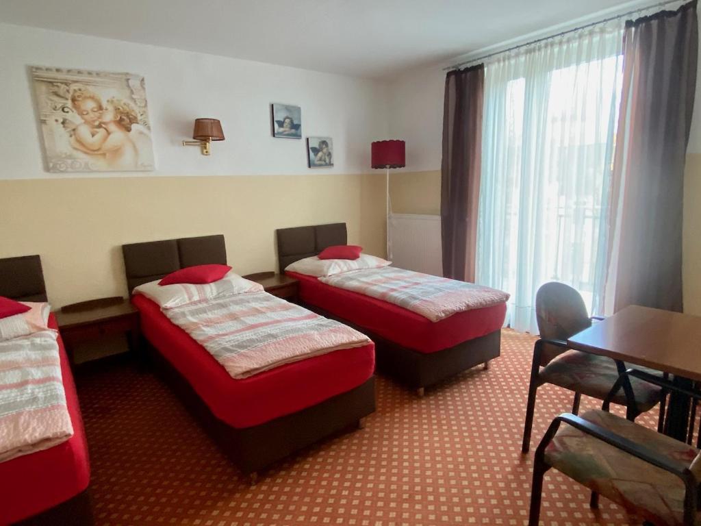 Cette chambre comprend 2 lits et une table. dans l'établissement Eurostopas, à Brême