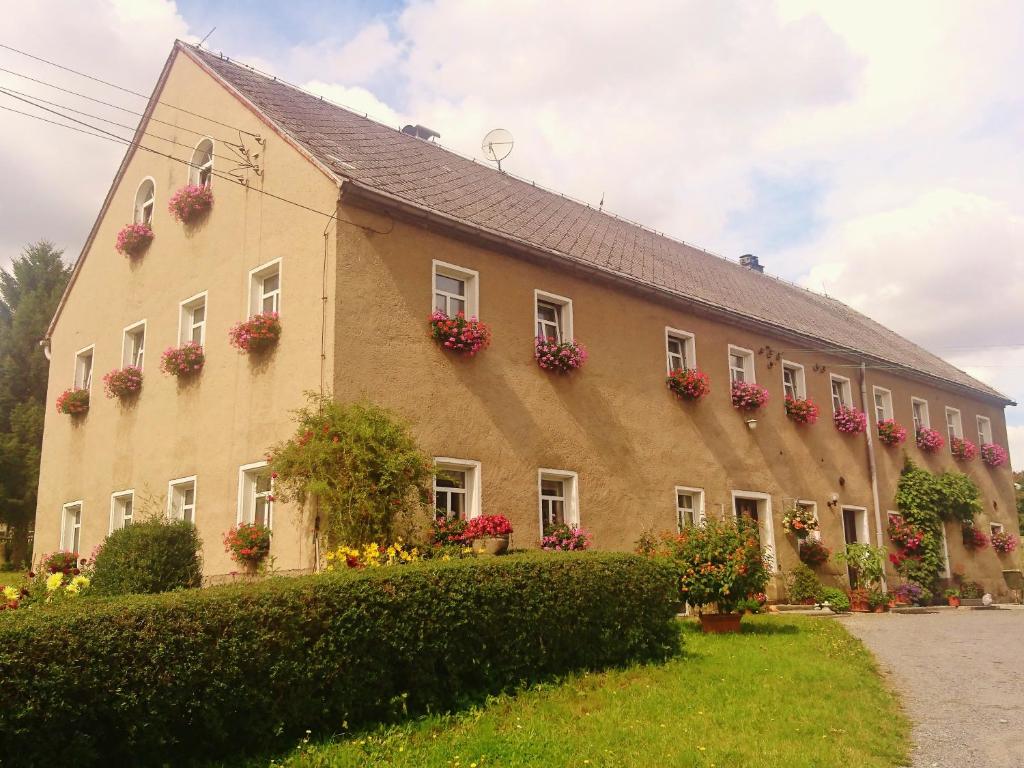un grand bâtiment avec des boîtes de fleurs sur les fenêtres dans l'établissement Ferienwohnung Herpich, à Ehrenberg