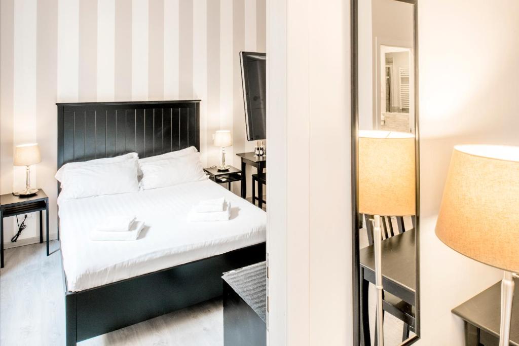 a bedroom with a bed and a mirror at Piazza Cavour Suite in Rome