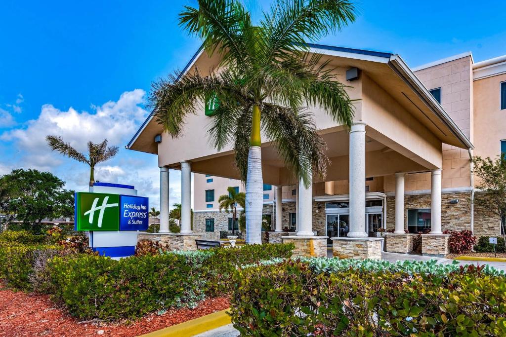 a building with a palm tree in front of it at Holiday Inn Express & Suites Lantana, an IHG Hotel in Lantana