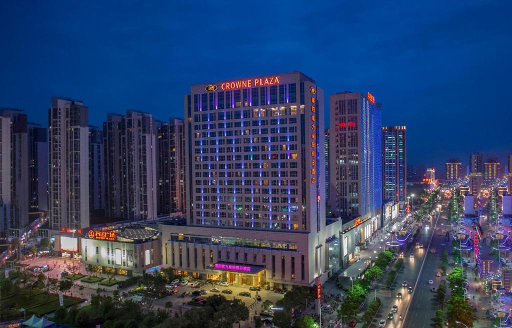 Crowne Plaza Xiangyang, an IHG Hotel في شيانغيانغ: مبنى كبير عليه علامة في الليل