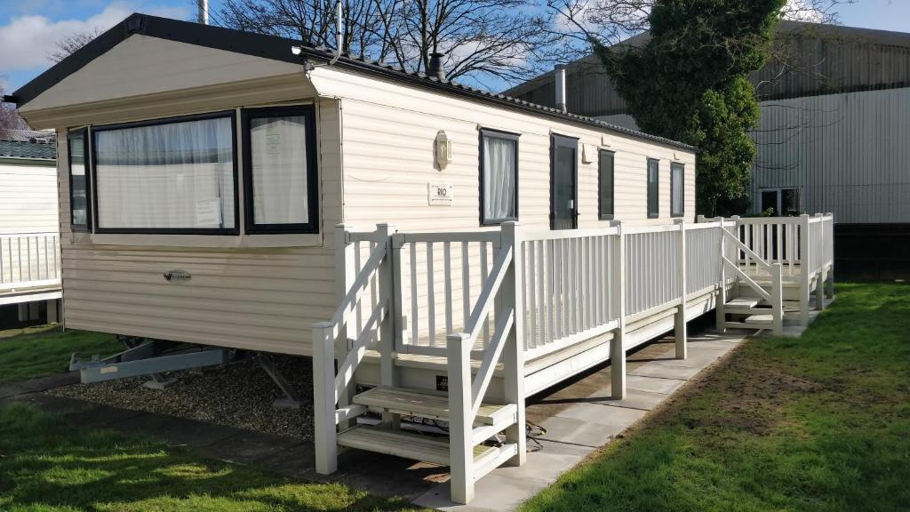 a white tiny house parked in a yard at 8 Berth Caravan Northshore Skegness Rio in Skegness