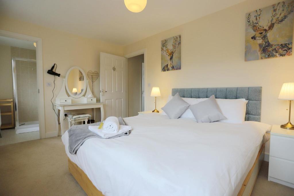 a bedroom with a large white bed and a mirror at EasyTravel Luxury NEC/Airport 3 beds House in Birmingham