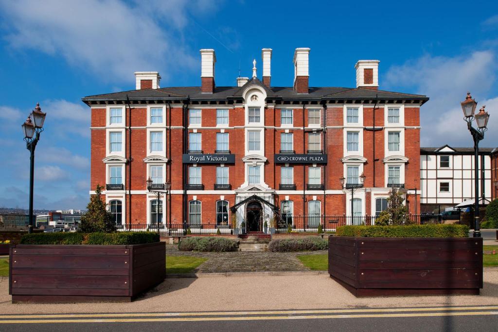 a large red brick building with two chimneys at Crowne Plaza Royal Victoria - Sheffield by IHG in Sheffield
