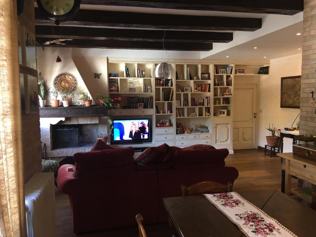 ein Wohnzimmer mit einem Sofa und einem TV in der Unterkunft Appartamento Pescoluce in Pescocostanzo