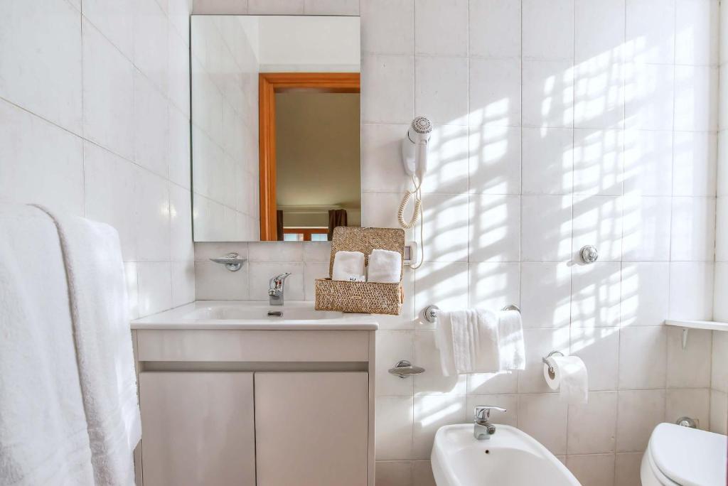 a white bathroom with a sink and a mirror at Plaza Rooms Ciampino in Ciampino