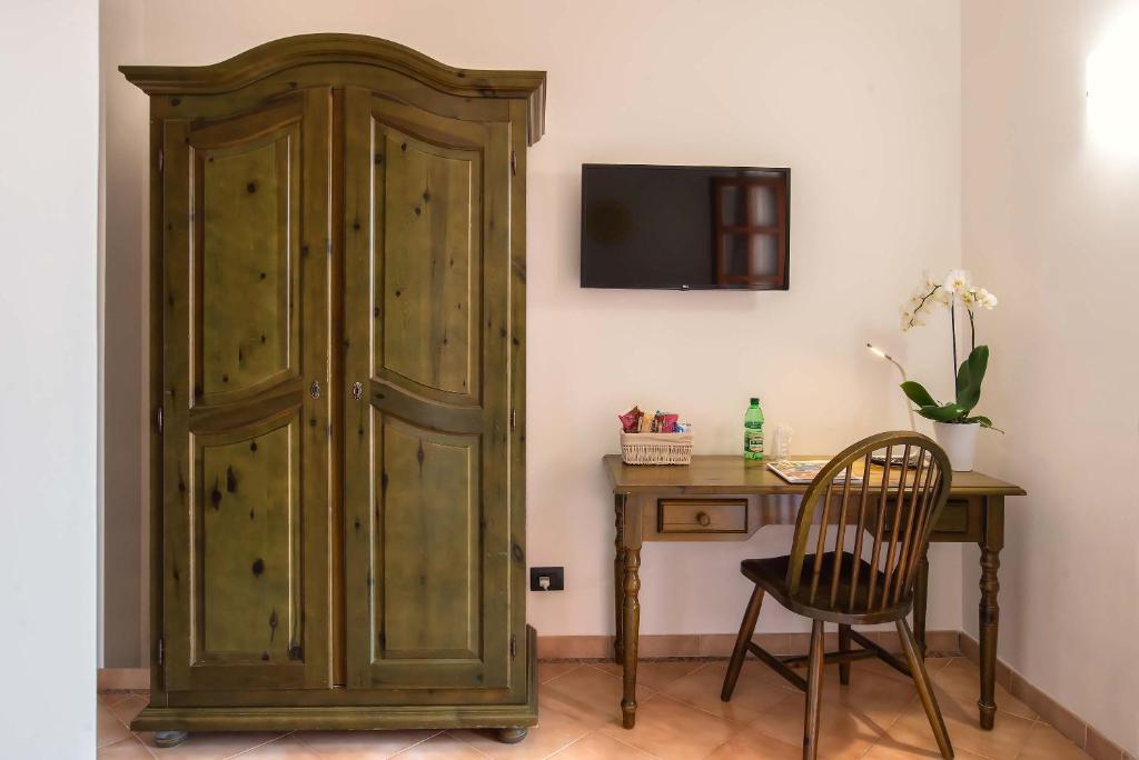 a wooden cabinet next to a desk with a chair at Plaza Rooms Ciampino in Ciampino