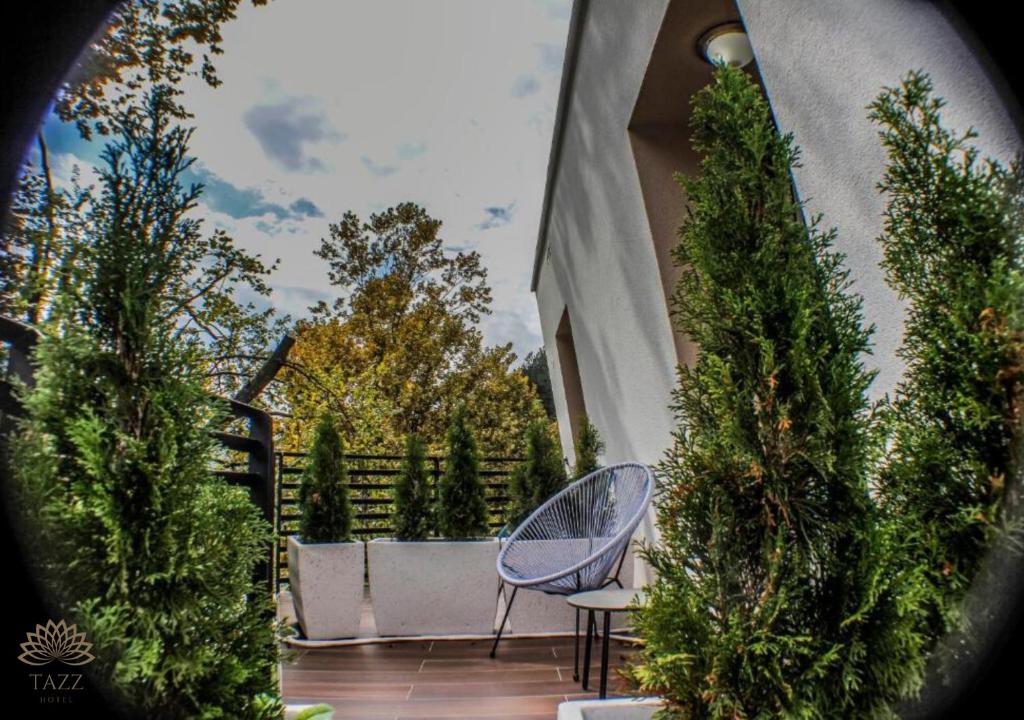 a blue chair sitting on a patio with trees at Hotel Tazz - River Front Oasis Collection in Bihać