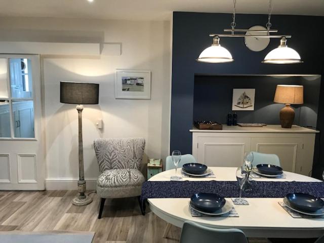 a living room with a table and a chair at Rosie’s on the Crescent in Filey