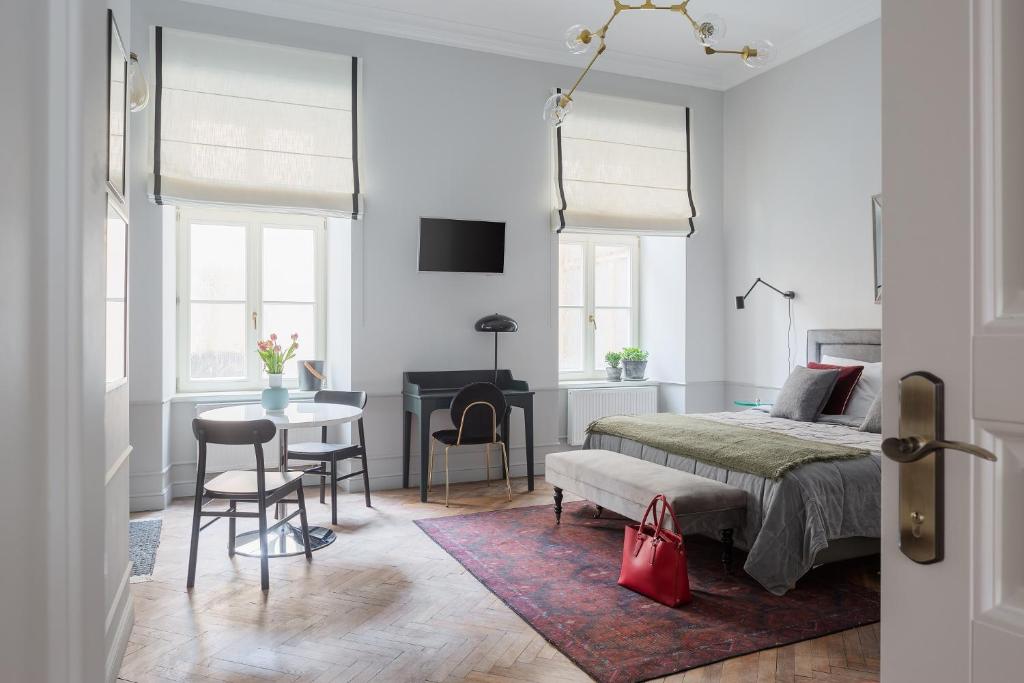 Un dormitorio blanco con una cama, una mesa y sillas. en Jana 3 Apartments, en Cracovia