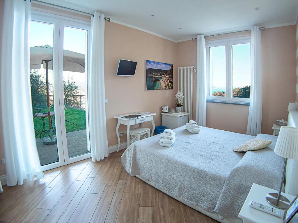 1 dormitorio con cama, mesa y balcón en Agriturismo La Pietra, en La Spezia