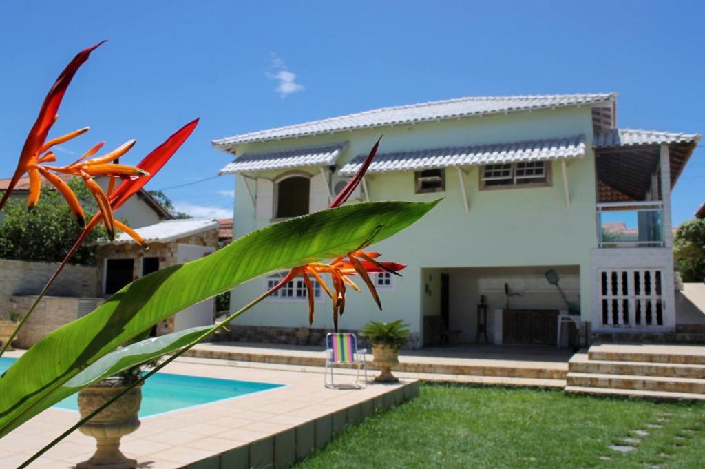 a house with a swimming pool in front of it at Casa Temporada Saquarema in Saquarema