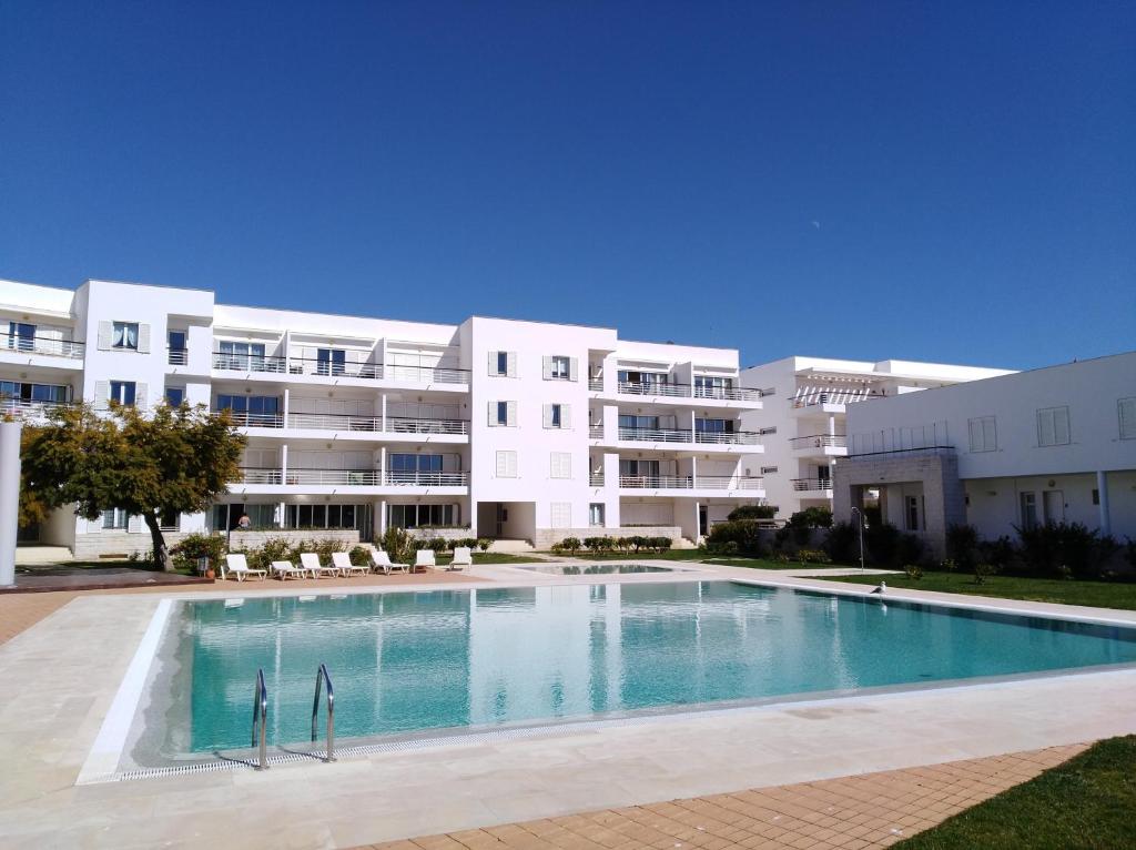 una piscina vacía frente a un gran edificio de apartamentos en Dom Manuel, en Lagos