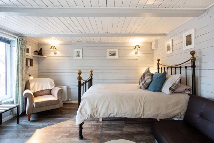 a bedroom with a bed and a chair at Loughview chalet in Whitehouse Lower