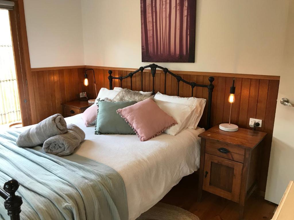 a bedroom with a bed with pillows on it at The Green Room Wattle Glen in Wattleglen