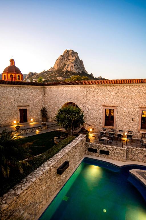 a swimming pool in front of a building with a mountain at Casa Mateo Hotel Boutique in Bernal