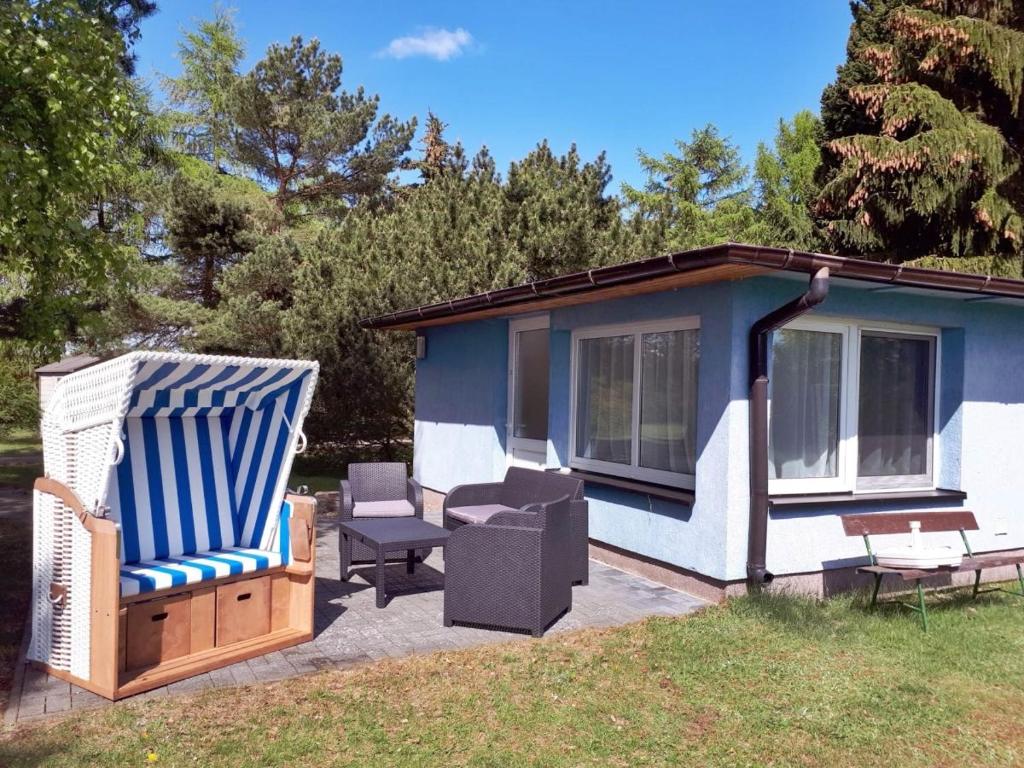 ein blau-weißes Haus mit einem Stuhl und einer Terrasse in der Unterkunft Inselglück Usedom in Kamminke
