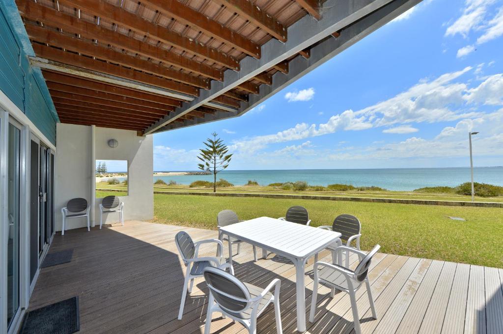 a patio with a table and chairs and the ocean at Sea Side Villa 10.1 in Mandurah